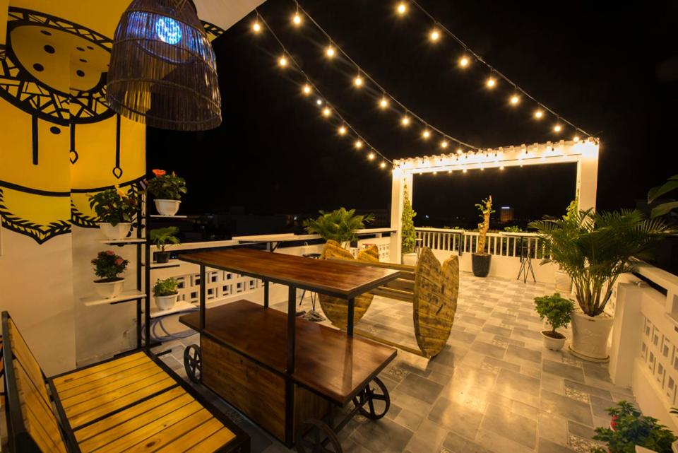 a patio with a table and chairs and lights at Nẫu House in Tuy Hoa