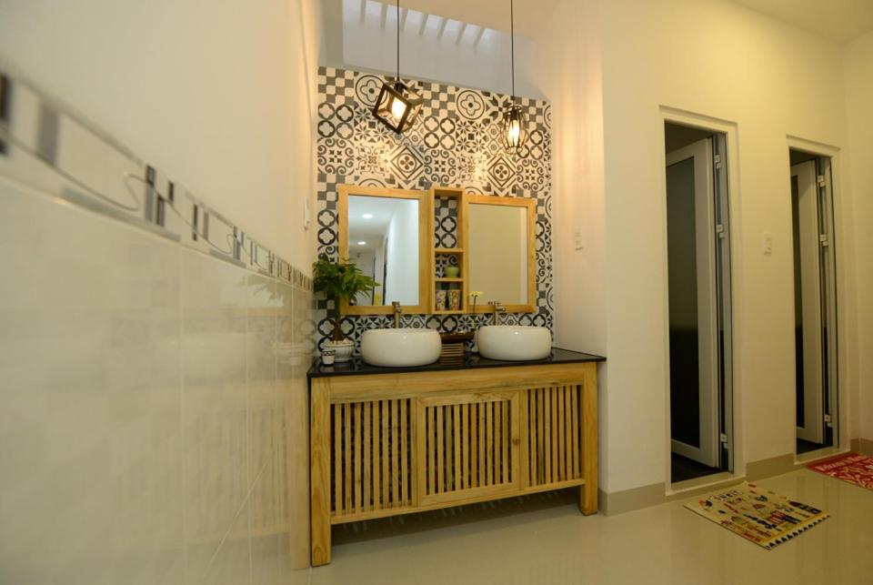 a bathroom with two sinks and a mirror at Nẫu House in Tuy Hoa