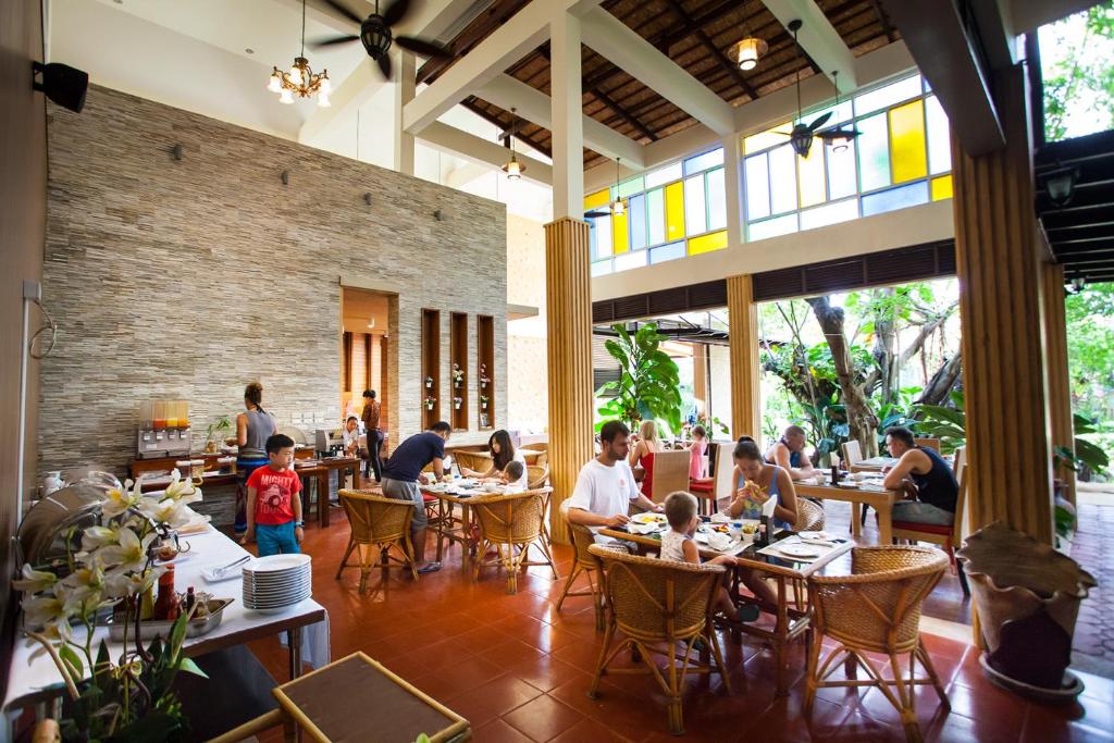 eine Gruppe von Menschen, die an Tischen in einem Restaurant sitzen in der Unterkunft Pattra Vill Resort in Lamai