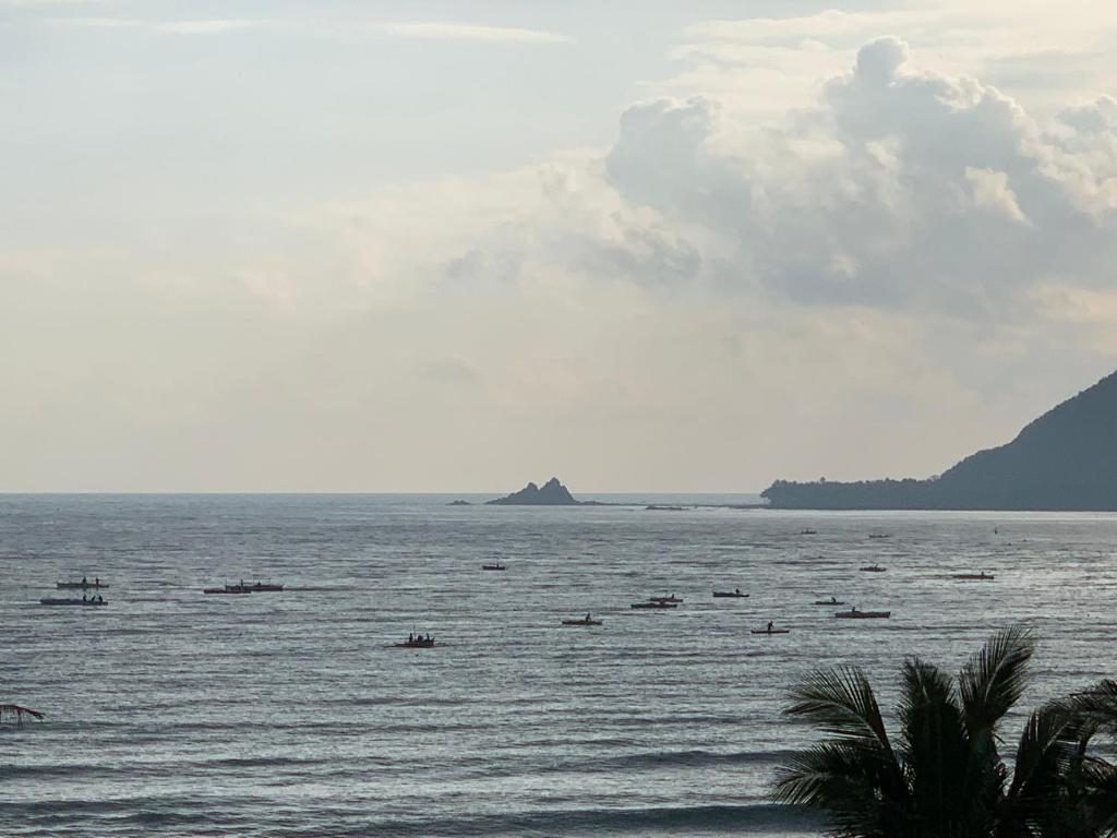 a large body of water with people swimming in it at Isaguirre's Pension House in Baler