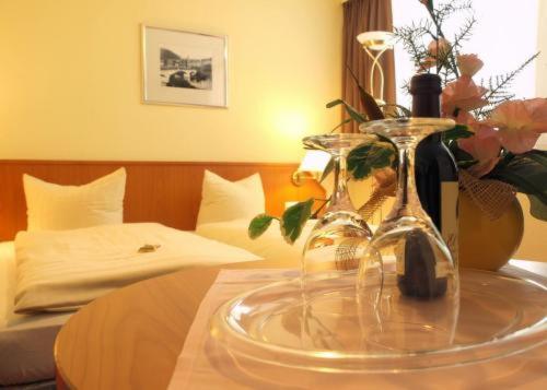 a table with a glass plate with a bottle of wine at Hotel Am Schlossberg in Ziegenrück