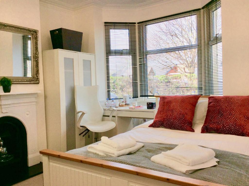 a bedroom with a bed with red pillows and a desk at Station House in Didcot