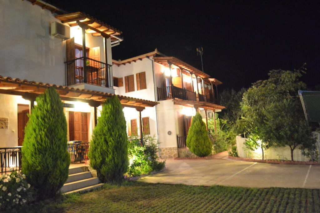 a large white house at night with lights at Iliachtides in Kala Nera