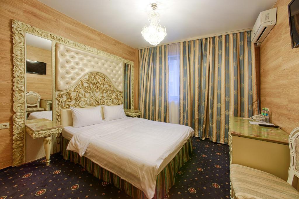 a hotel room with a bed and a mirror at Sunflower Avenue Hotel Moscow in Moscow