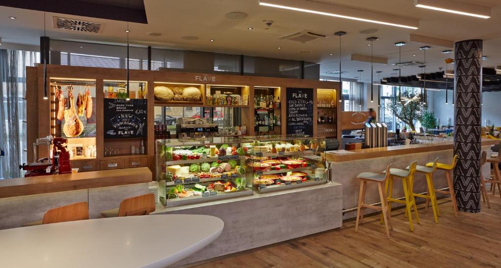 a restaurant with a counter with food on display at Novotel München City Arnulfpark in Munich