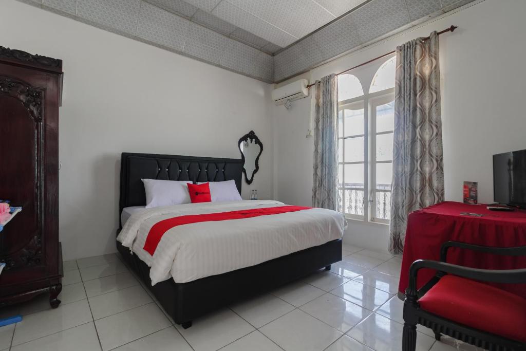 Un dormitorio con una cama grande y una ventana en RedDoorz Syariah near Universitas Negeri Padang en Padang