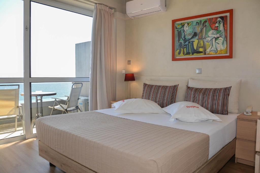 een slaapkamer met een bed en uitzicht op de oceaan bij Scorpios Sea Side Hotel in Piraeus