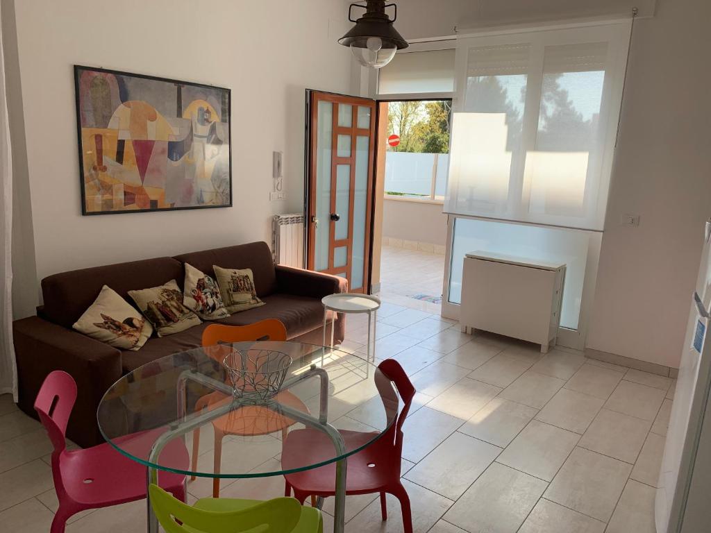 - un salon avec une table en verre et un canapé dans l'établissement Appartamento pineta a mare, à Montesilvano