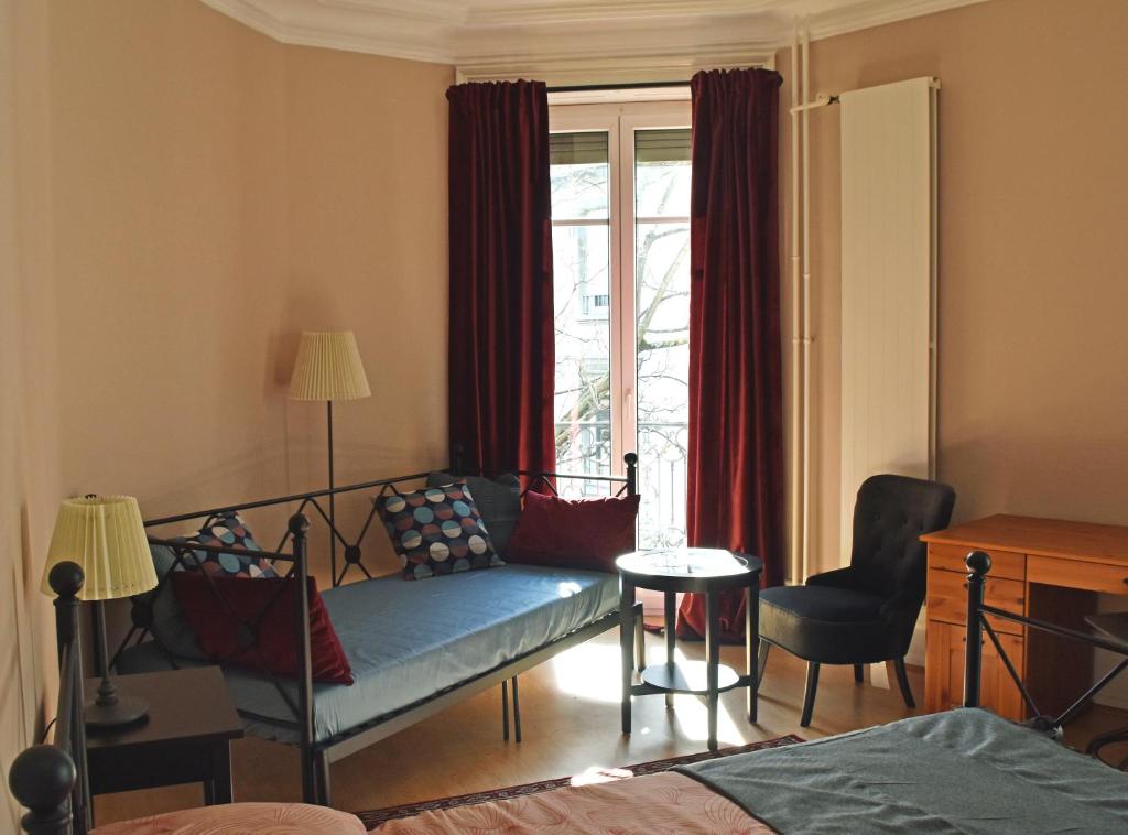 a living room with a couch and a window at Pension Bienvenue (Women only) in Lausanne