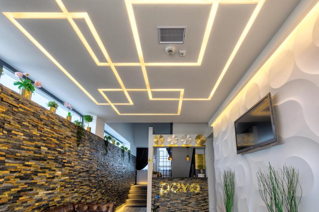 a ceiling design for a lobby with a stone wall at Pensiune Pavo in Piteşti