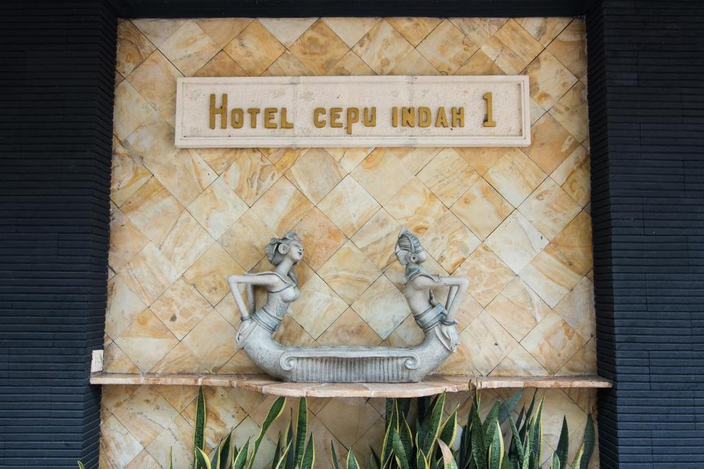 a statue of two women in a bidet on a wall at Hotel Cepu Indah 1 in Cepu