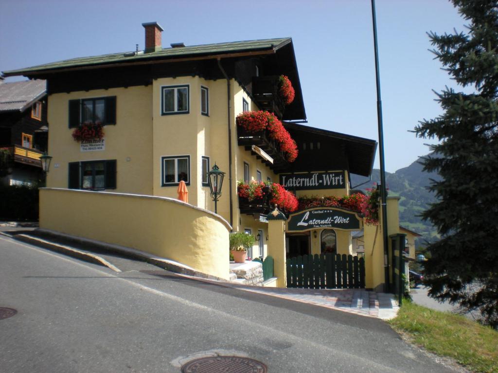a building on a street with flowers on the windows at Laterndl-Wirt in Sankt Veit im Pongau