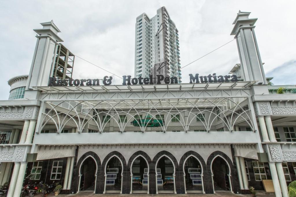 a building with a sign on top of it at Hotel Pen Mutiara in Kampong Batu Maung