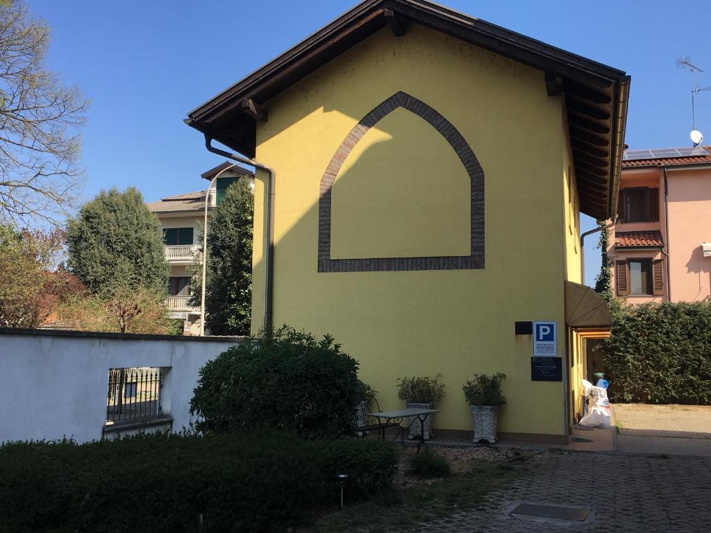 een gebouw met een boog op de zijkant geschilderd bij Hotel Il Pino in Garlasco