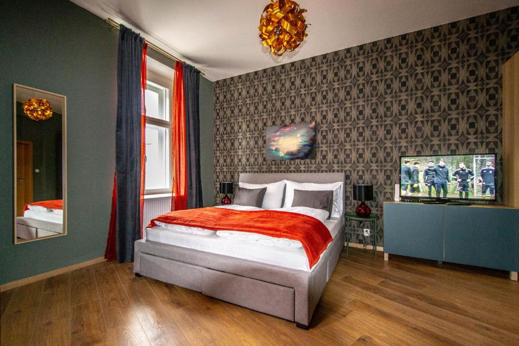een slaapkamer met een bed met een rode deken bij Ruterra Apartments by Cathedral in Praag