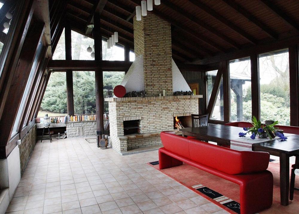 - un salon avec une cheminée et un canapé rouge dans l'établissement Inn66, à Amecke