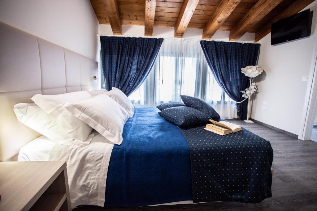 a bedroom with a bed with a blue blanket at HOME HOTEL in Castelfranco Veneto