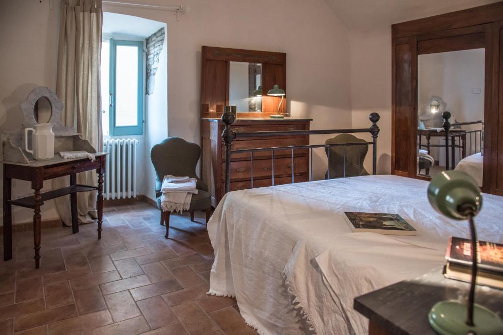 - une chambre avec un grand lit et un bureau dans l'établissement Foresteria Terra Majura, à Terni