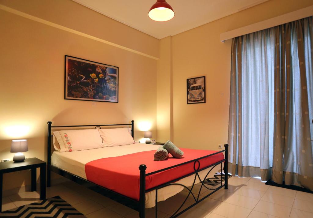 ein Schlafzimmer mit einem Bett mit einer roten Decke in der Unterkunft Kleisthenes' apartment in Athen