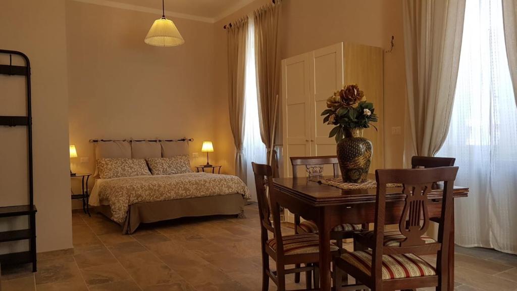 a bedroom with a bed and a table with a vase of flowers at La Salita B&B in Viterbo