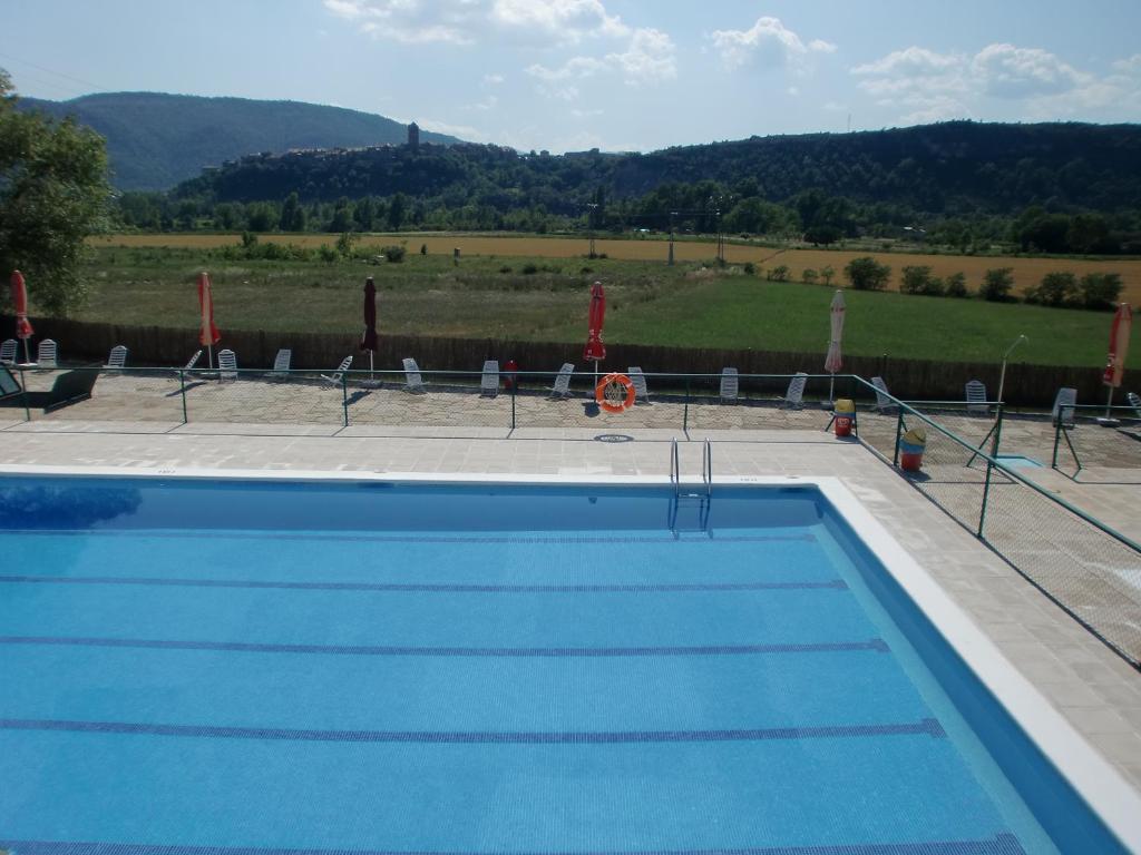 a swimming pool with a view of a field at Camping Ainsa in Aínsa