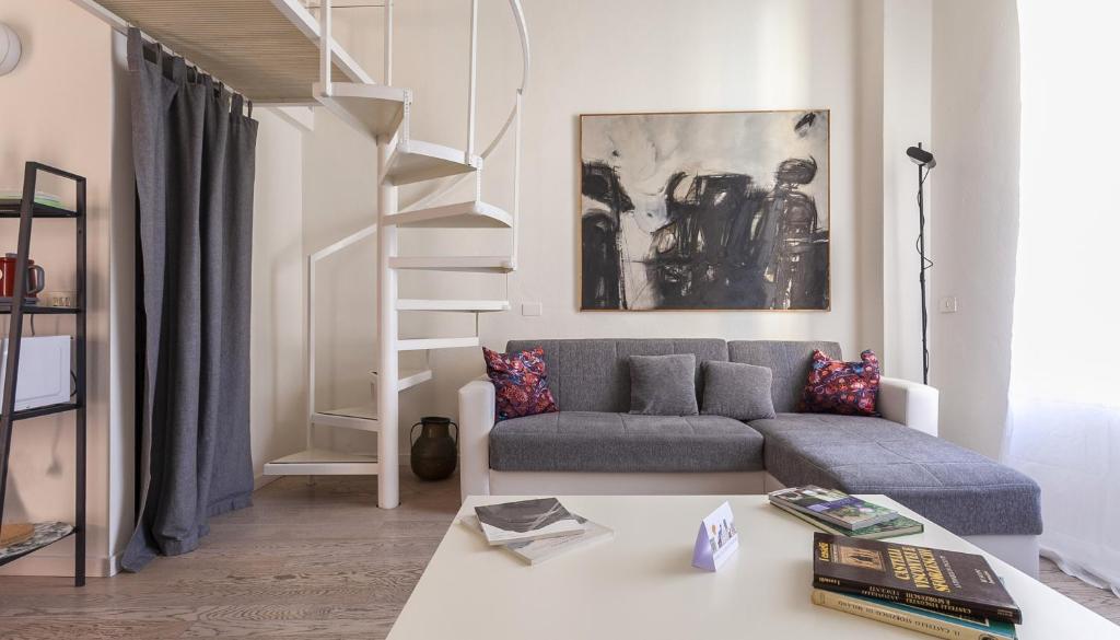 a living room with a couch and a staircase at Italianway - Ripa di Porta Ticinese 17 in Milan