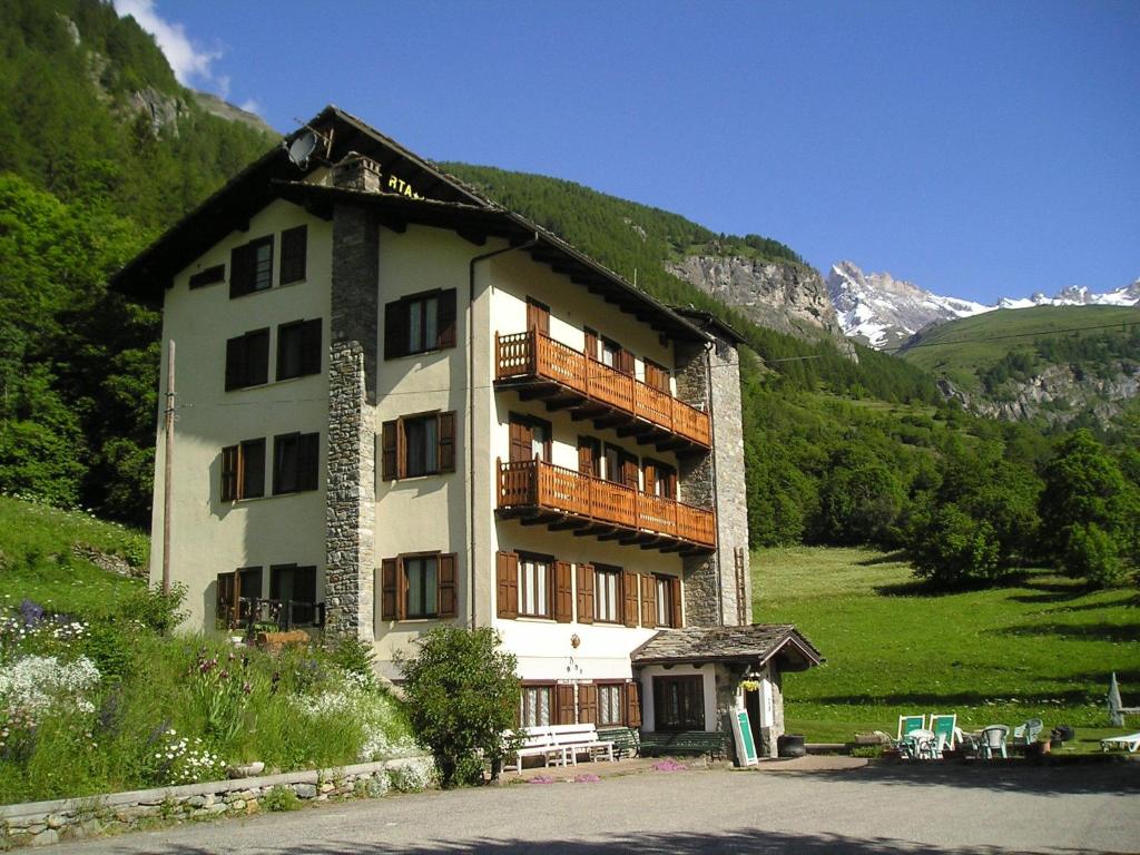 een groot gebouw met een balkon in de bergen bij Mont Gelé in Ollomont