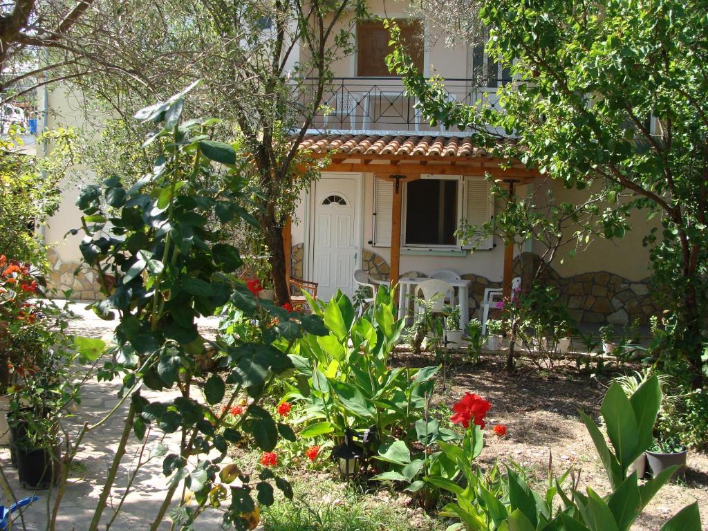 uma casa com um jardim com flores em frente em Villa Galini em Nikiana