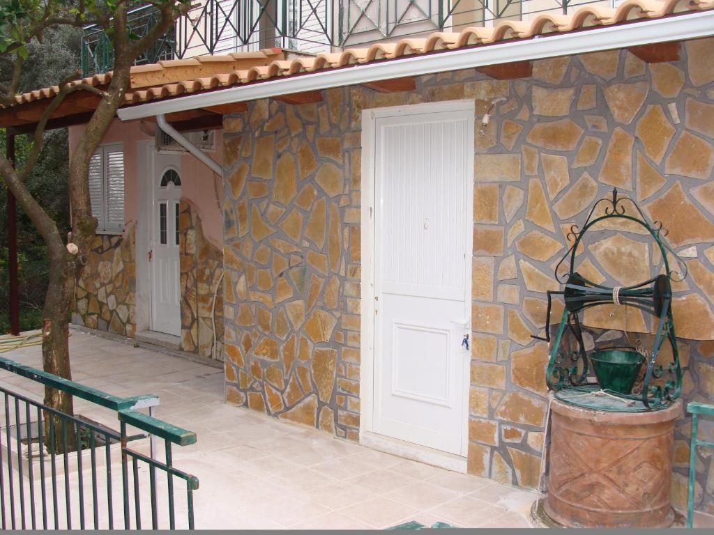 ニキアナにあるVilla Galiniの白い扉とポーチのある石造りの家