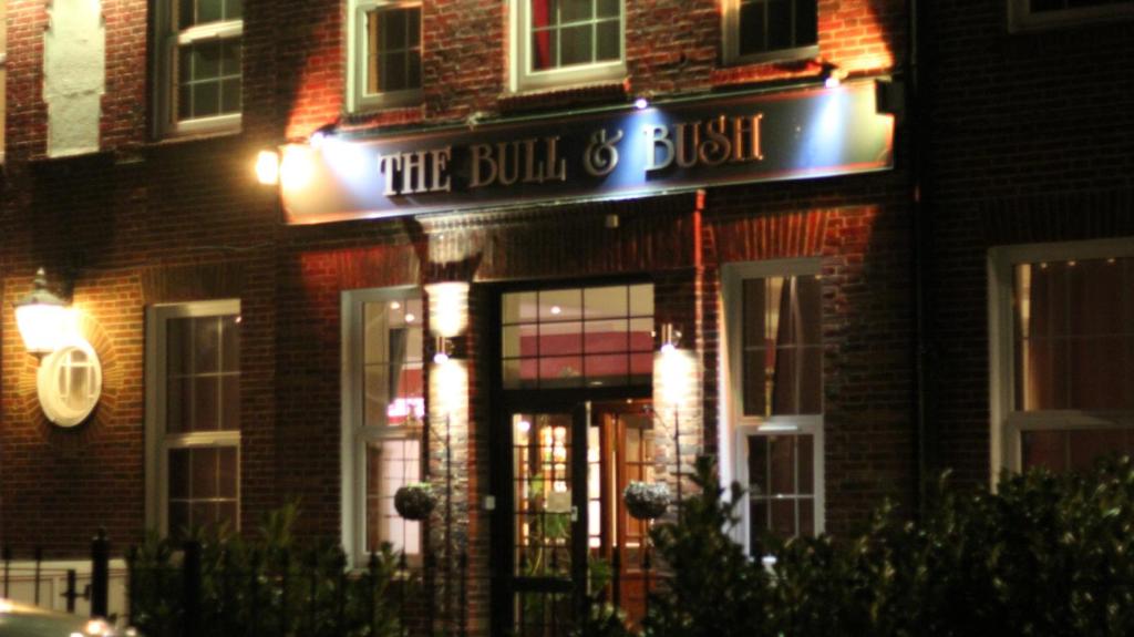 un edificio con una señal que lee el toro y el arbusto en The Bull and Bush Hotel Kingston, en Kingston upon Thames