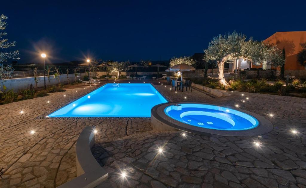 ein Schwimmbad in einem Garten in der Nacht in der Unterkunft Dimora Villa Ada in Chiaramonte Gulfi