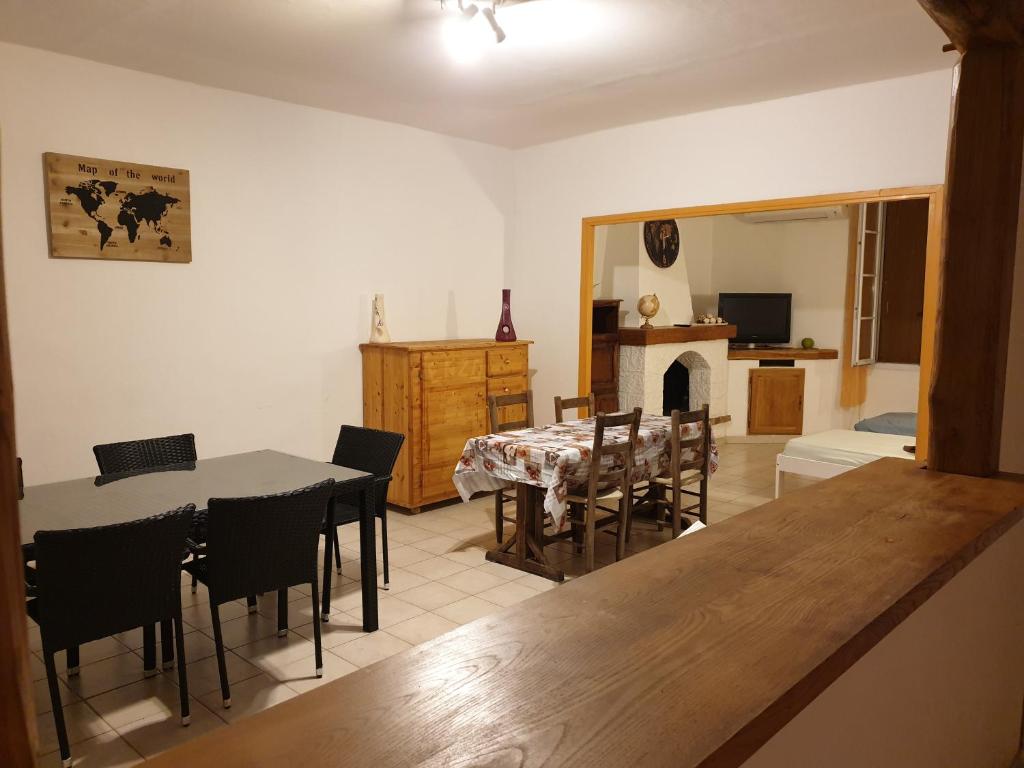 a dining room and living room with a table and chairs at LE GÎTE LA BLAQUIÉRE in Cendras