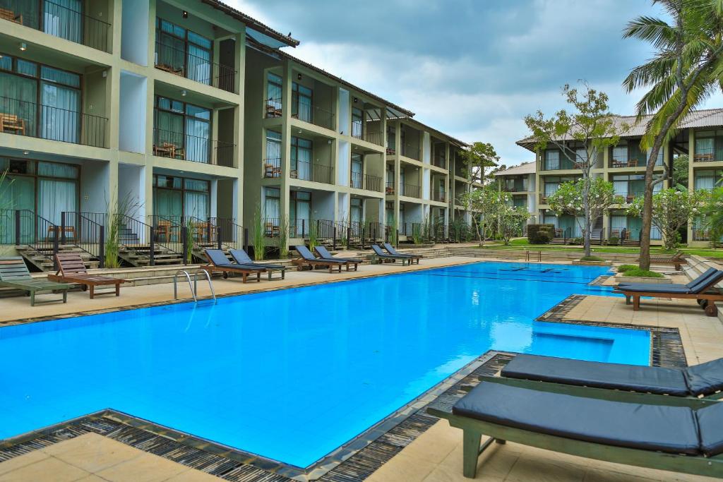 a large swimming pool in front of a building at Fresco Water Villa in Sigiriya
