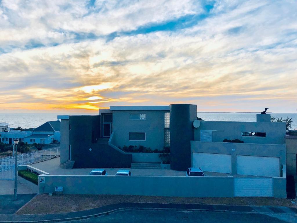 a building with a sunset in the background at Small Bay Beach Suites in Cape Town