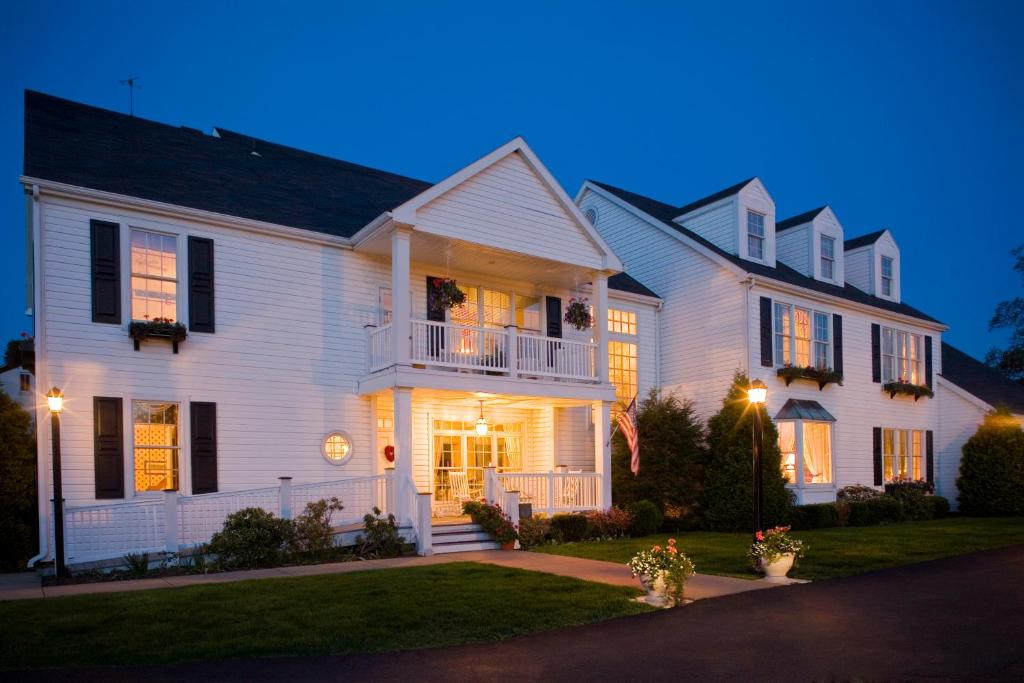 a large white house with a porch at night at Oakmont Inn in Verona
