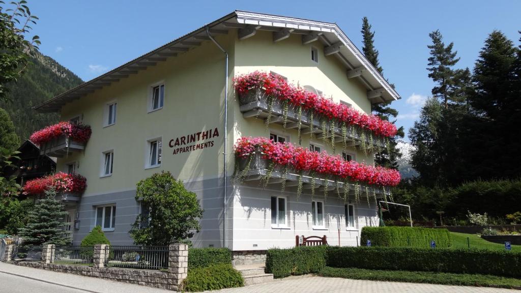 un edificio con flores a un lado. en Carinthia Appartements, en Mallnitz
