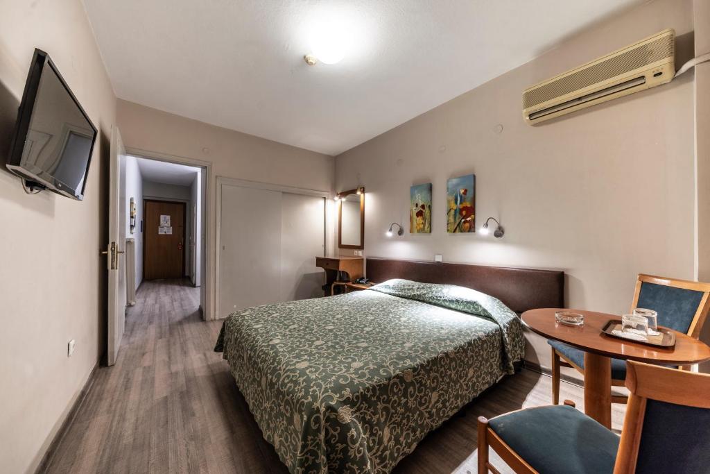 una camera d'albergo con letto e tavolo di Vergina Hotel a Salonicco