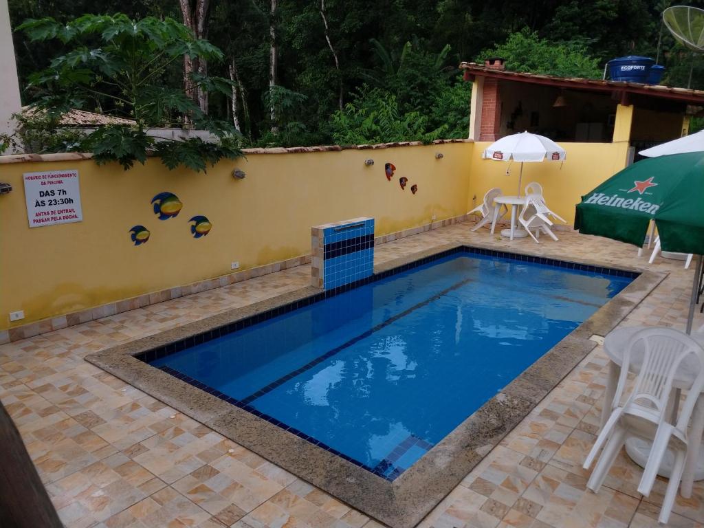 een zwembad voor een resort met een tafel en stoelen bij Recanto Sol de Verão in Paraty