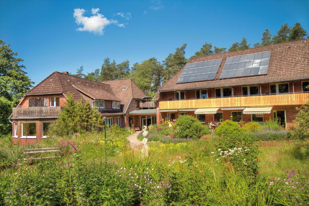 ein großes Haus mit Garten davor in der Unterkunft Biohotel Spöktal in Bispingen