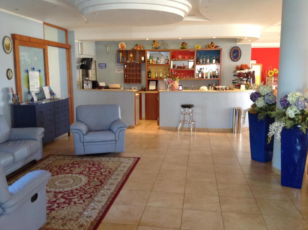 a living room with a couch and a bar at Hotel Corallo in Torre Santa Sabina