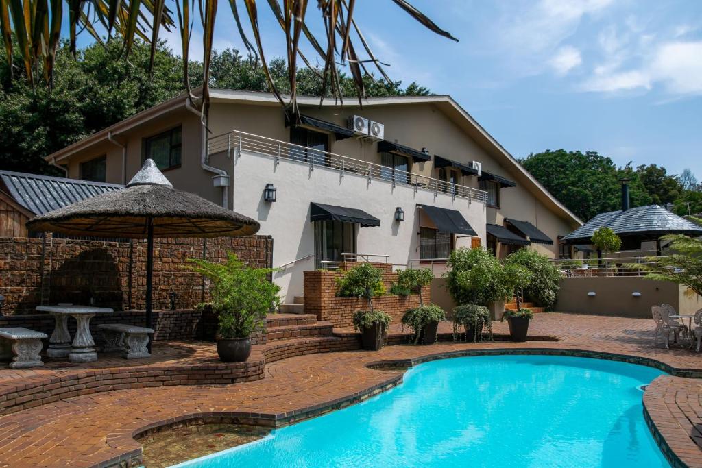 a hotel with a swimming pool in front of a building at 125 on Van Buuren Road Guest House in Johannesburg