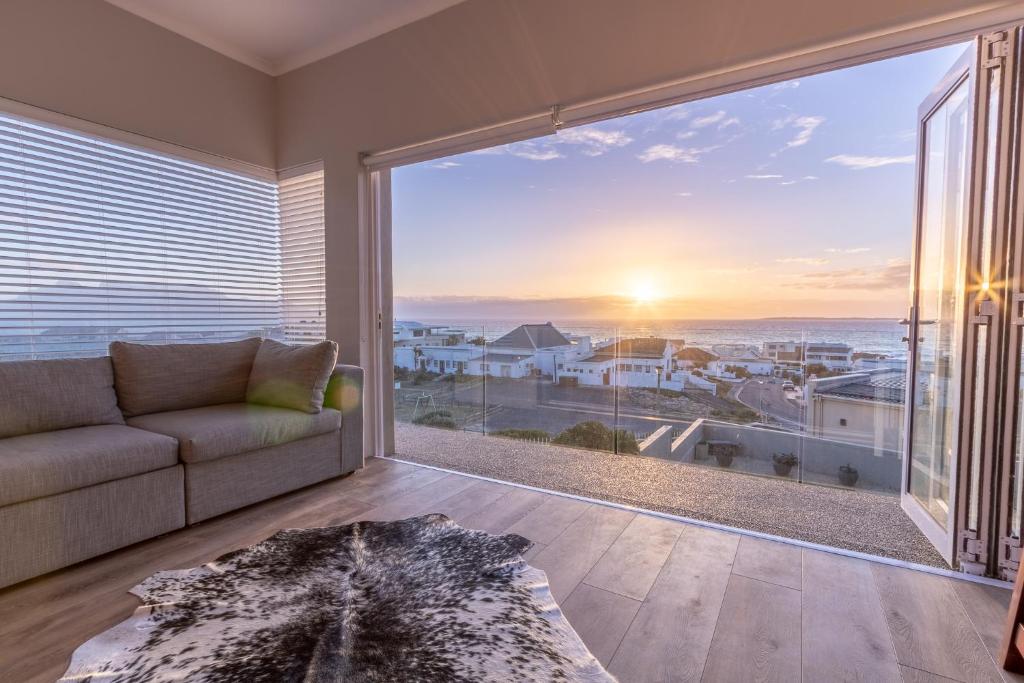 a living room with a couch and a large window at Small Bay Beach Suites in Cape Town