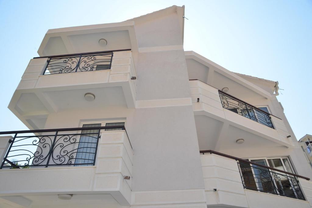 een wit gebouw met balkons aan de zijkant bij Apartments Mianiko in Herceg-Novi