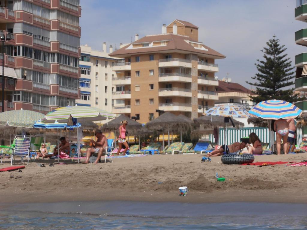 Grupa ludzi na plaży z parasolami w obiekcie Apartamentos Mary w mieście Fuengirola