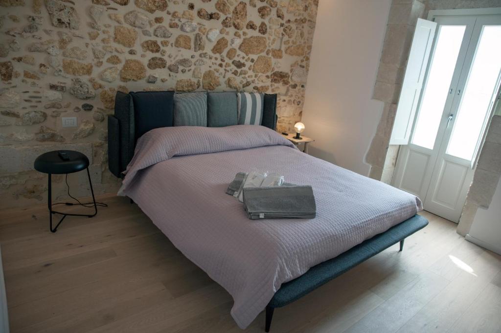 a bedroom with a bed with a purse on it at 4 Elements Boutique Home in Siracusa