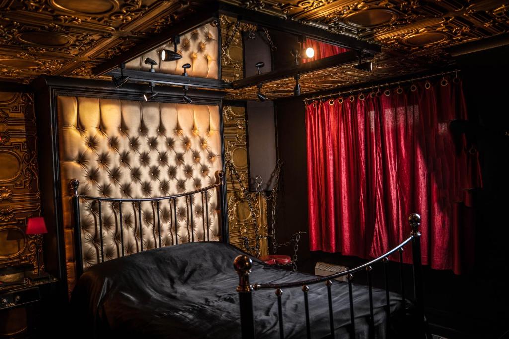 um quarto com uma cama e uma cortina vermelha em Brighton Erotic Boudoir em Brighton & Hove
