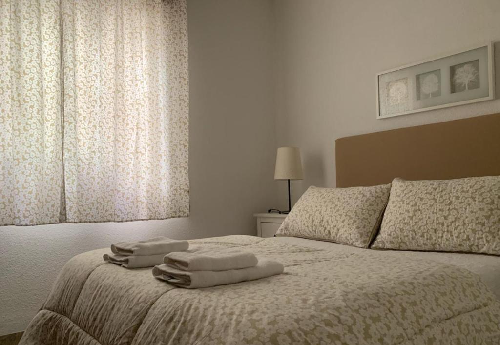 1 dormitorio con 1 cama con 2 toallas en Apartamento Ciudad Jardín con PARKING, en Córdoba