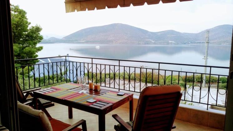 a balcony with a table and chairs and a view of the water at Ruby's house in Chalkida