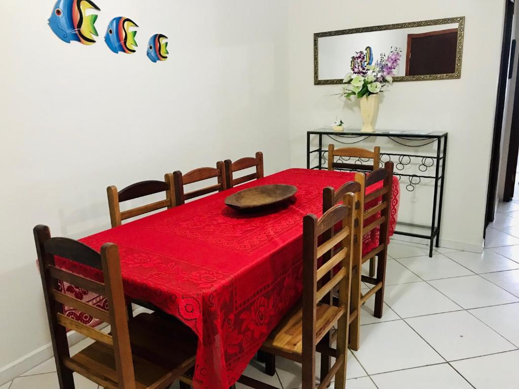 a dining room with a red table and chairs at Condominio residencial Ubatuba in Ubatuba