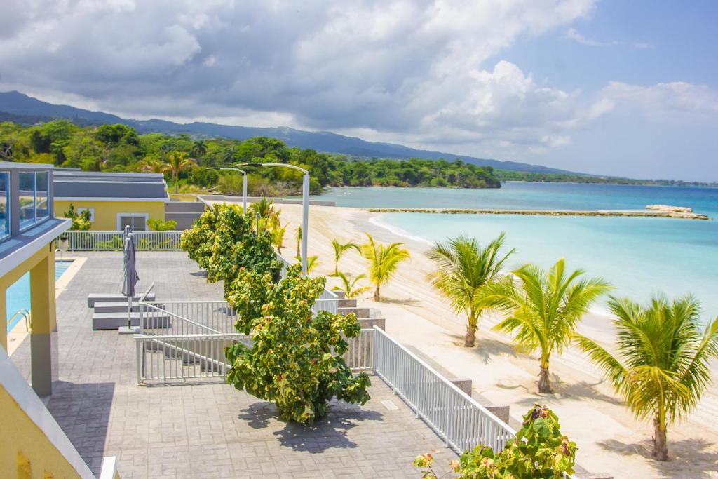 a view of a beach with benches and palm trees at The Marina Villa de Sonja in Ocho Rios